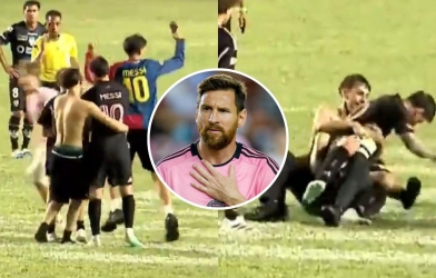 A shirtless man embraces Messi right on the field.