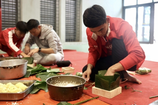 The captain of Vietnam U23 skillfully demonstrates how to wrap traditional square sticky rice cakes.