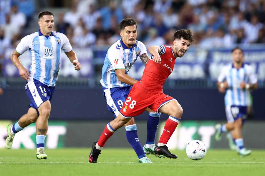 Javi Hernandez of Espanyol is challenged by Chupe of Malaga Javi Hernandez of Espanyol is challenged by Chupe of Malaga