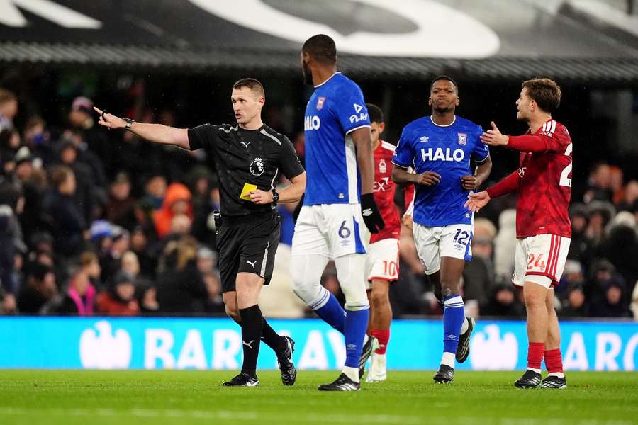 Referee Thomas Bramall (left) shows a yellow card to Ipswich Town's Issa Diop after a VAR check. Referee Thomas Bramall (left) shows a yellow card to Ipswich Town's Issa Diop after a VAR check.