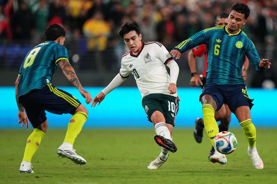 Mexico's Gilberto Mora is challenged by Colombia's Gustavo Puerta and Richard Rios Mexico's Gilberto Mora is challenged by Colombia's Gustavo Puerta and Richard Rios