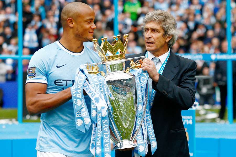 Vincent Kompany holding the 2013/14 Premier League title 