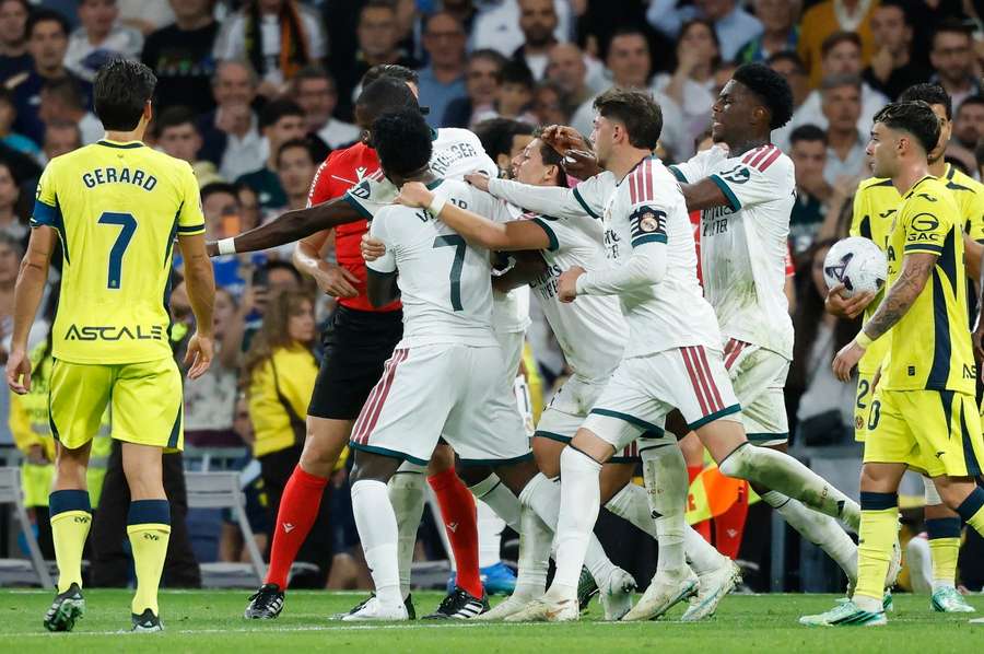 Vinicius is restrained by teammates after being sent off for pulling an opponent's hair